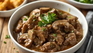 Keto Beef Stroganoff served in a white bowl with creamy mushroom sauce and fresh parsley garnish
