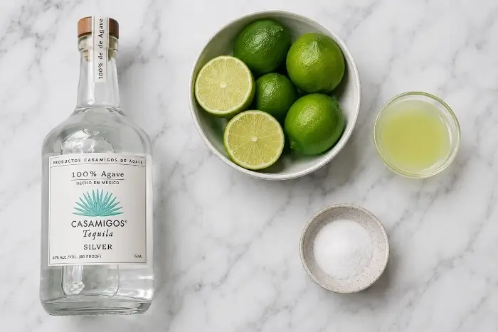 Ingredients for the best skinny margarita recipe including tequila, fresh limes, monk fruit sweetener, and sea salt
