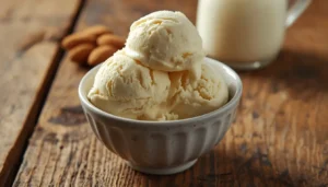 Creamy almond milk ice cream in a bowl with almonds and a pitcher of almond milk