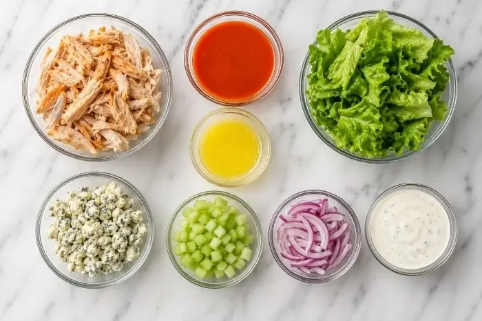 Fresh ingredients for keto buffalo chicken wraps including chicken, buffalo sauce, and lettuce