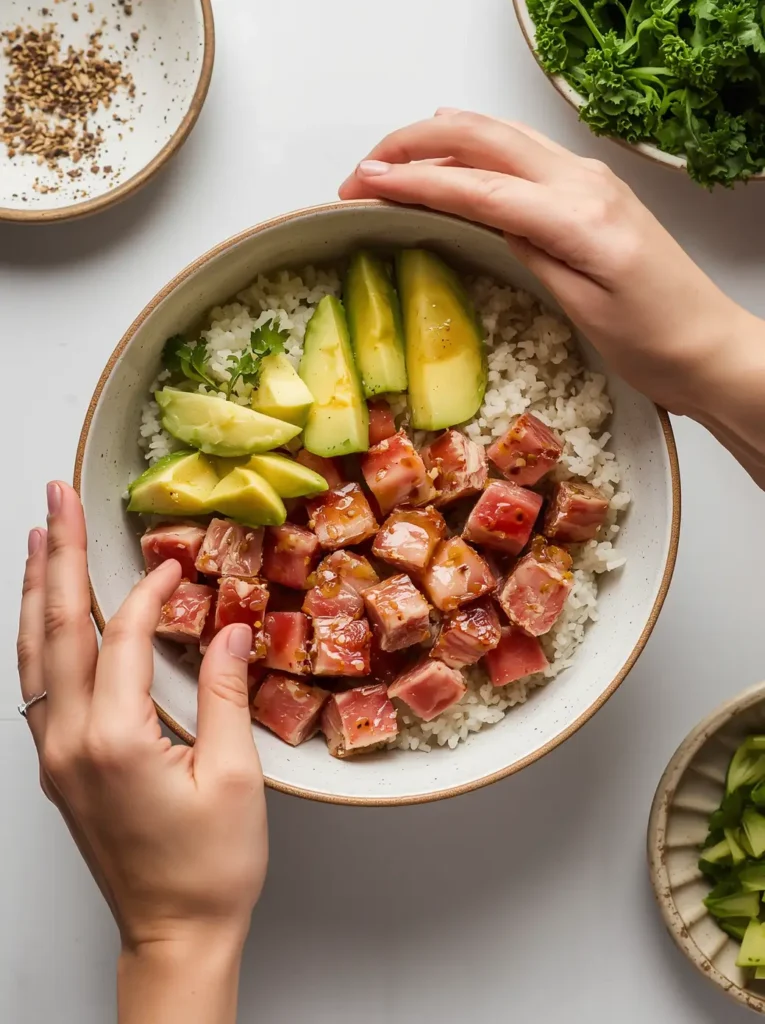 Assembling a keto poke bowl with avocado and marinated tuna