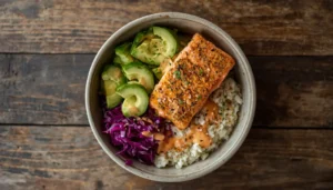 Overhead view of a keto salmon bowl with seared salmon, avocado, and cauliflower rice