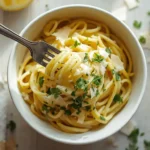 Bowl of creamy low-carb hearts of palm pasta topped with parsley and Parmesan